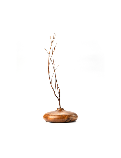 A handcrafted brown wooden vase with a rounded top and a visible wood grain texture.