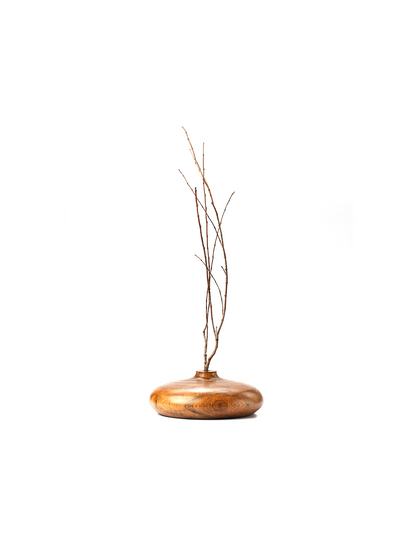 A handcrafted brown wooden vase with a rounded top and a visible wood grain texture.